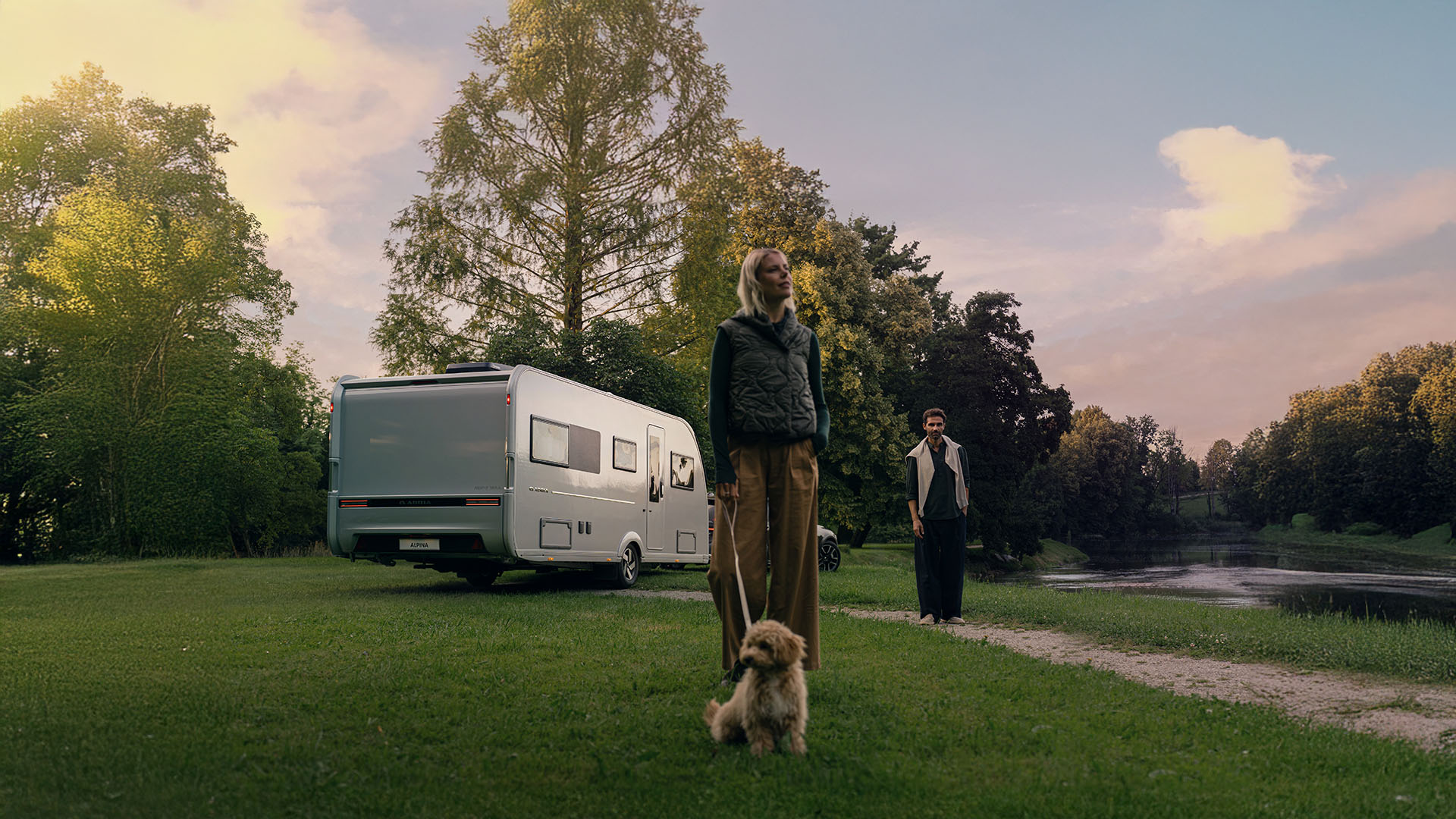 Photo extérieure de la nouvelle Adria Alpina en vert, avec des personnes et un chien