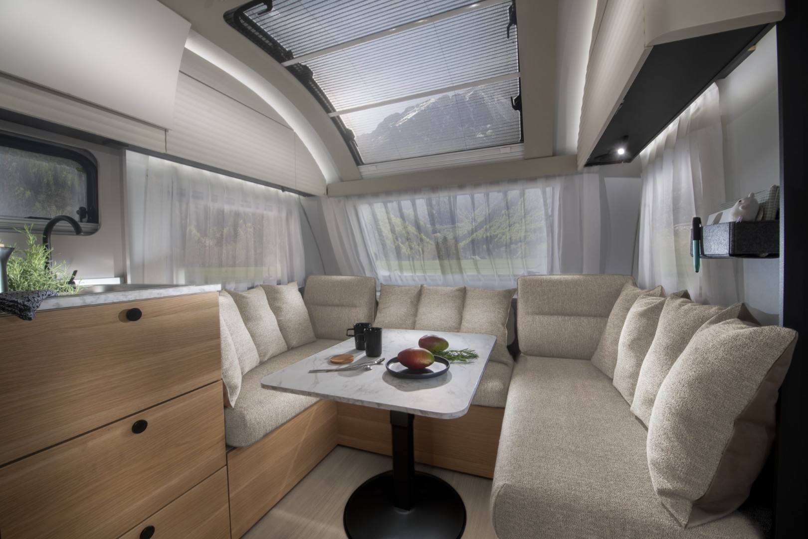 Salon en U dans l’Adora 572 UT, surplombé par la fenêtre panoramique Adria.