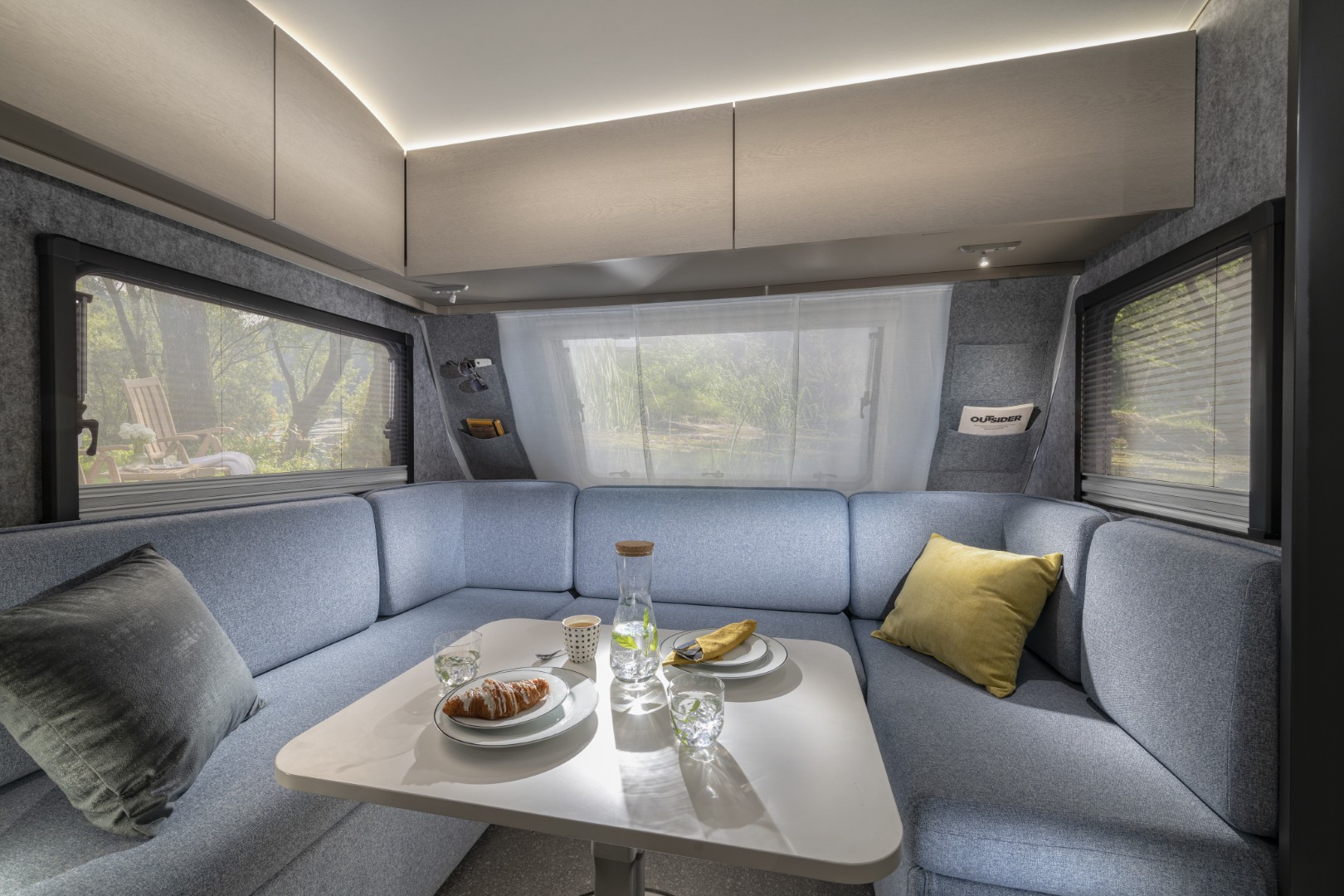 Caravane avec salon en U à l’avant et de nombreuses fenêtres tout autour