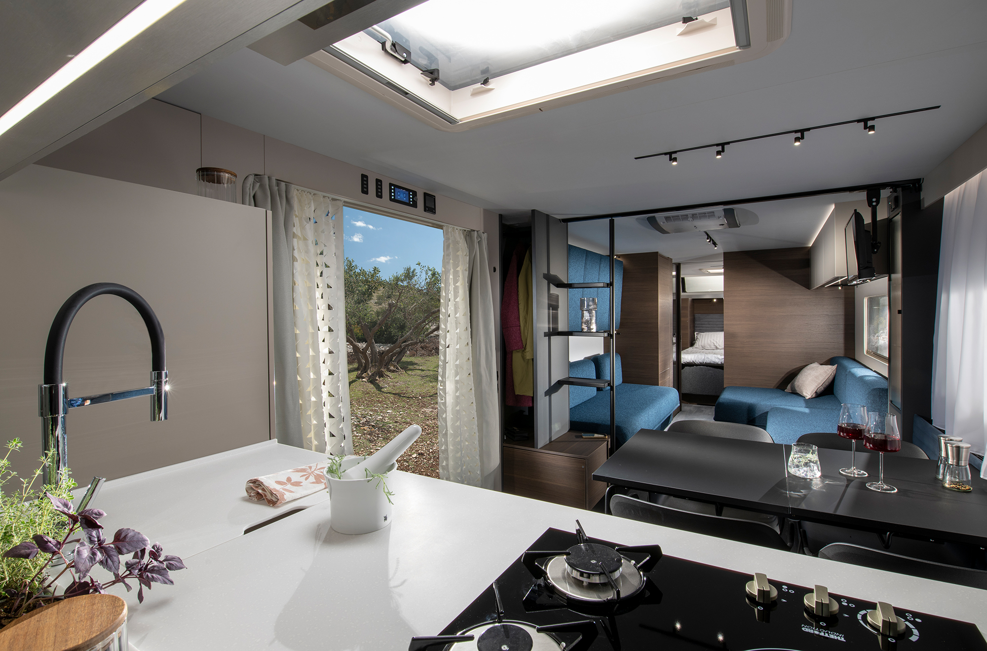 Der Blick von der Küche aus durch das Wohnzimmer des Luxus Wohnwagens ADRIA ASTELLA 904 HP bis hin zum Schlafzimmer.