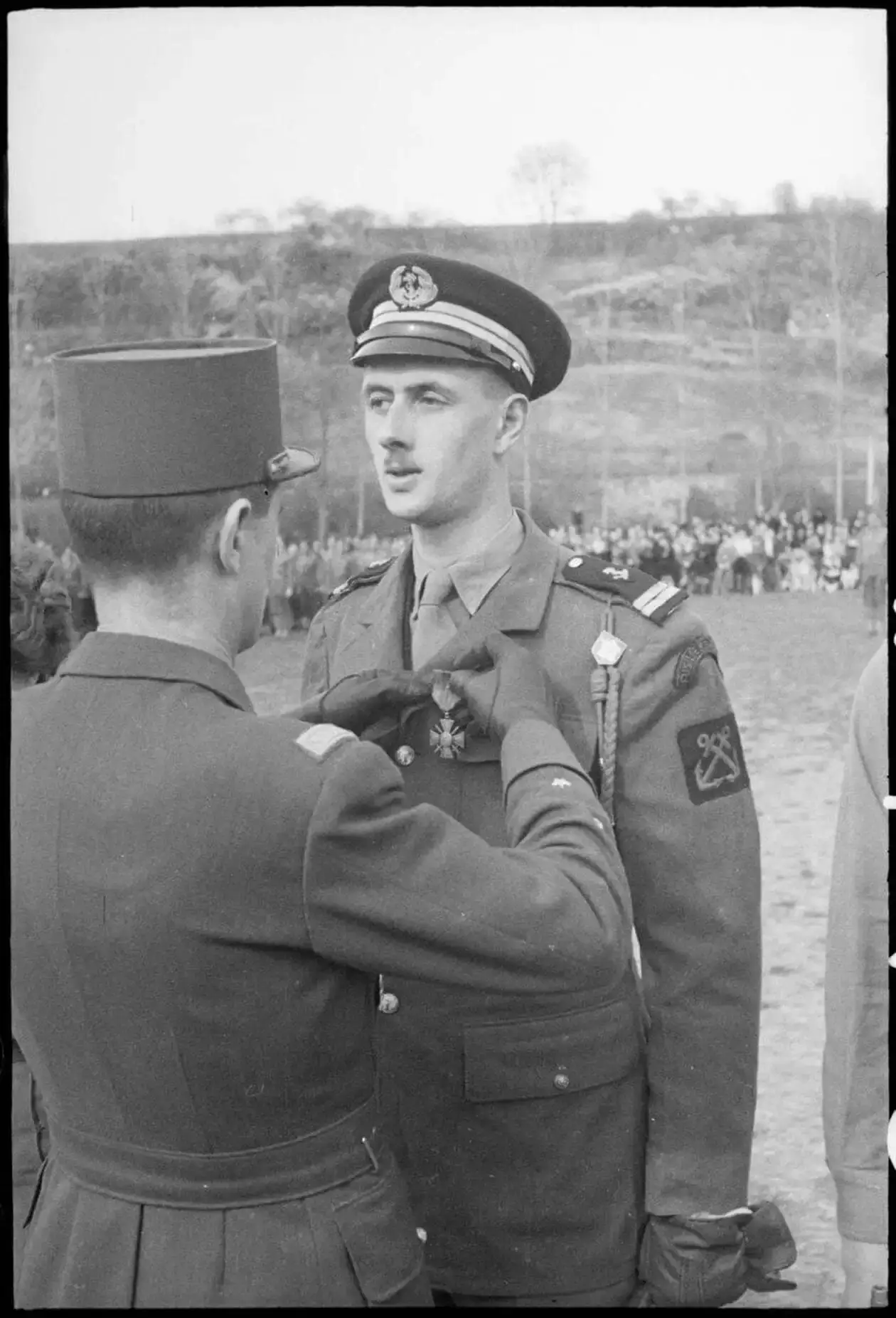 En avril 1945, pour sa contribution à la libération de la France, l'enseigne de vaisseau Philippe de Gaulle reçoit la Croix de guerre des mains du général Lelcerc_CEEM