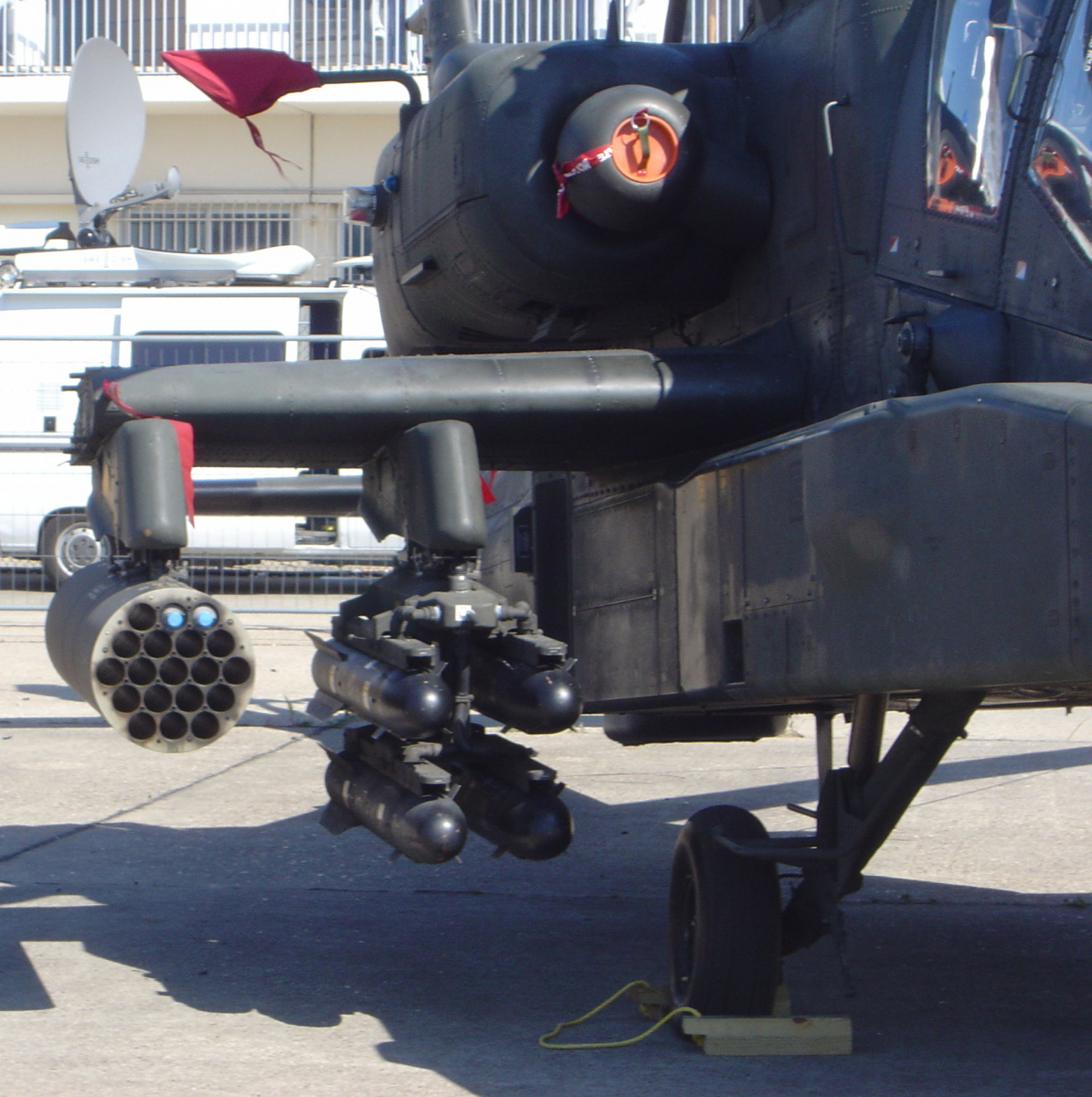 Les missiles Hellfire et les roquettes Hydra-70 sont stockés sur le côté des hélicoptères Apache, tel que visible sur la photographie.