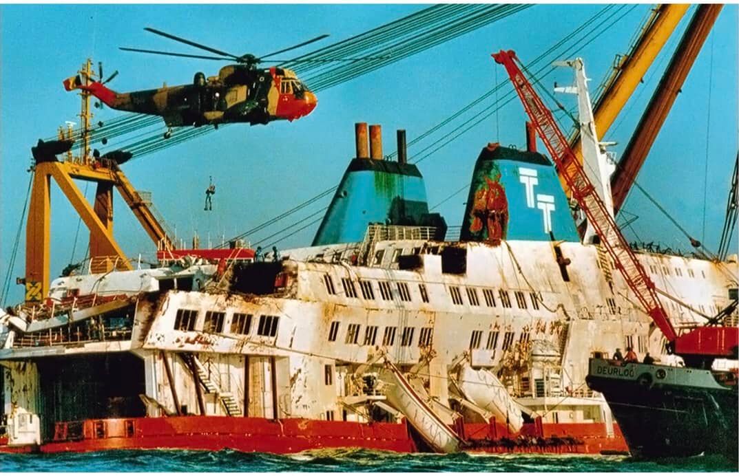 Un Sea King belge hélitreuille du personnel sur l'épave du bateau alors que le navire a été remis à flot longtemps après la tragédie. Jusqu'à leur remplacement par le NH-90 en 2019, les Sea King belges auront sauvé 1757 vies.
