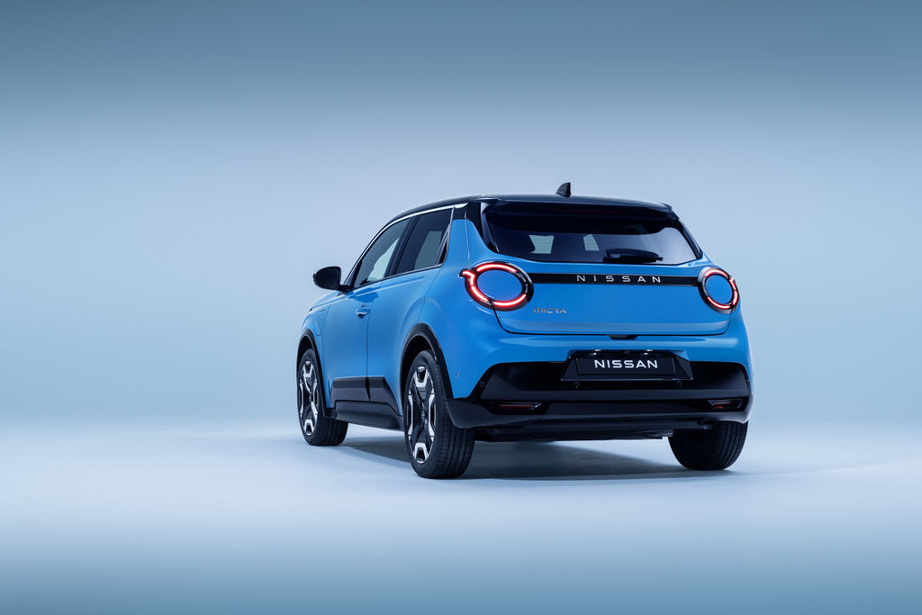 Content 4 view of micra in blue gear color showing signature lit headlamps. nissan name plate  driver   passenger doors  wheels  and black bumper