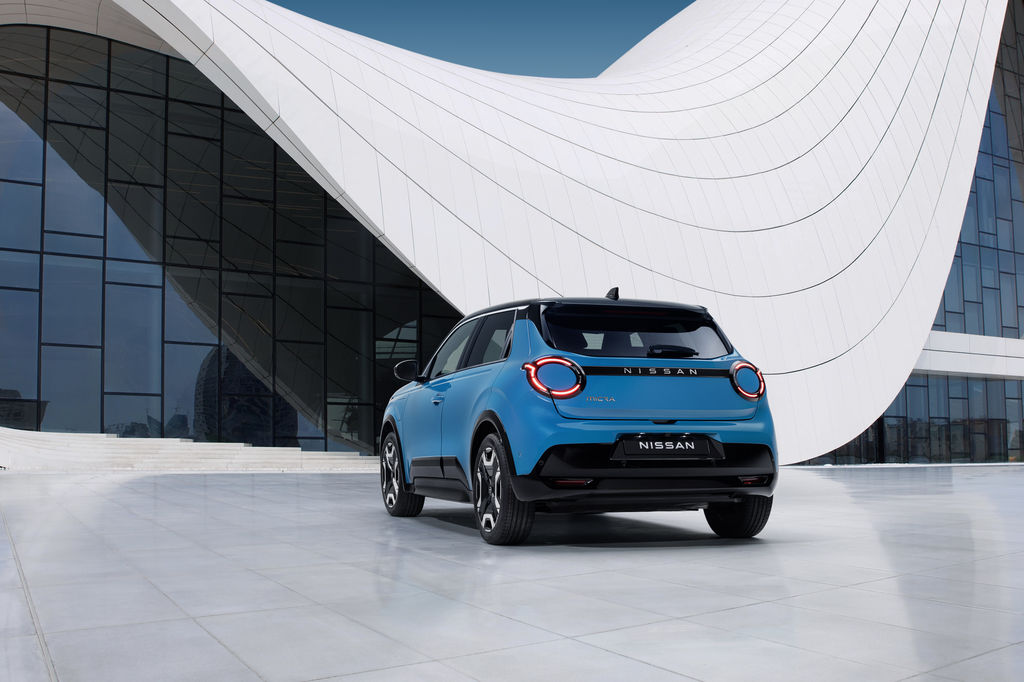 Content 8 view of new micra in blue gear color in front of a white   blue design architectural building