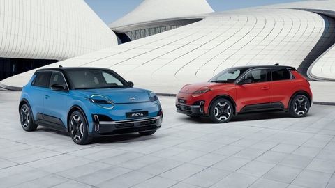 Thumb two iconic micras   gear blue color and red color   parked in front of a blue   white design architectural building in a v shape facing each other