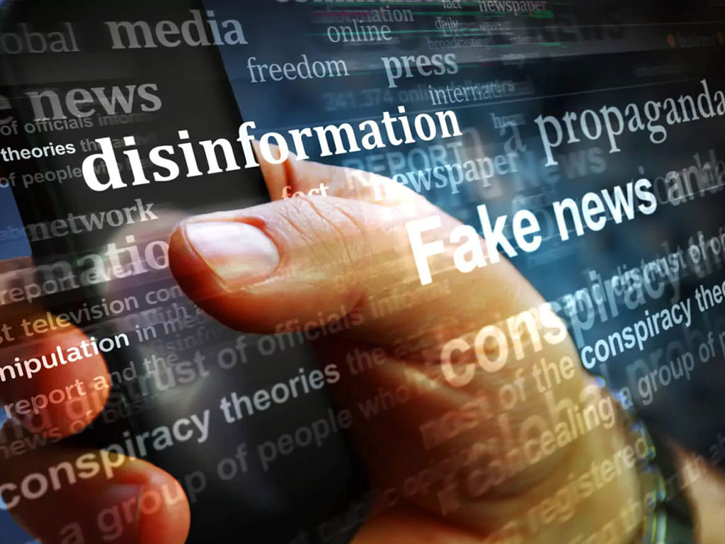 Imagine decor reprezentând un telefon ținut în mână și peste care apare text legat de dezinformare si Fake News