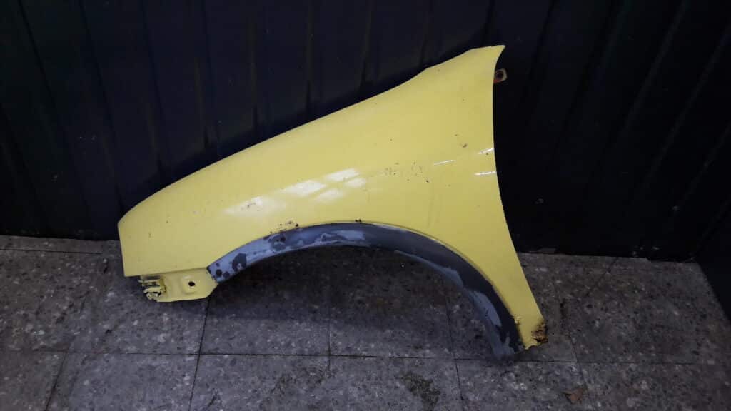 blotnik lewy przod Opel Corsa B zolty 94r