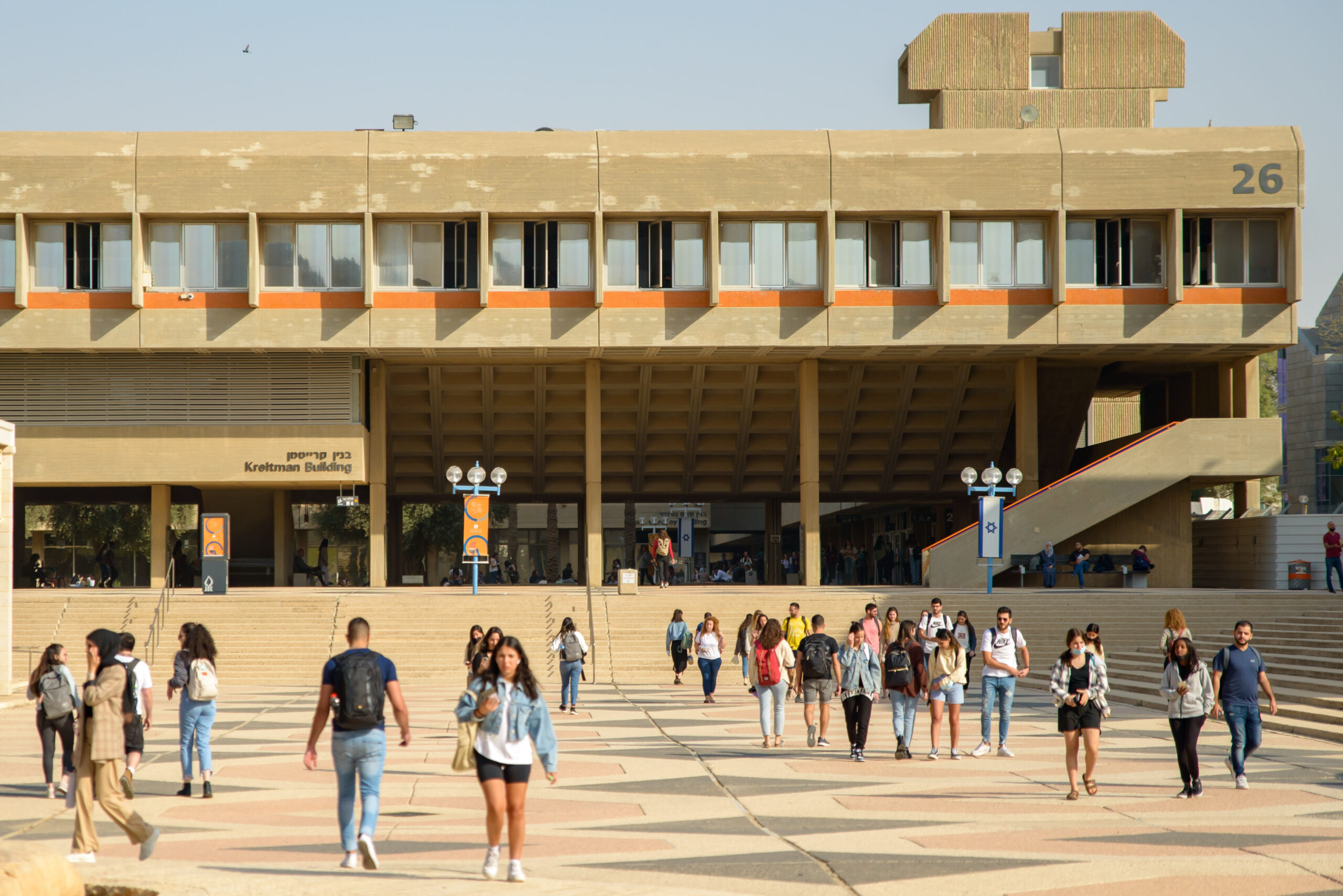 A crowded public plaza with modern architecture and many people walking around.