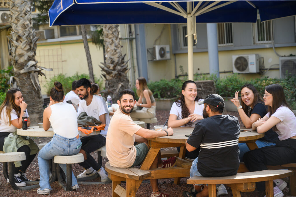 Outdoor cafe with a group of young people enjoying their time together.