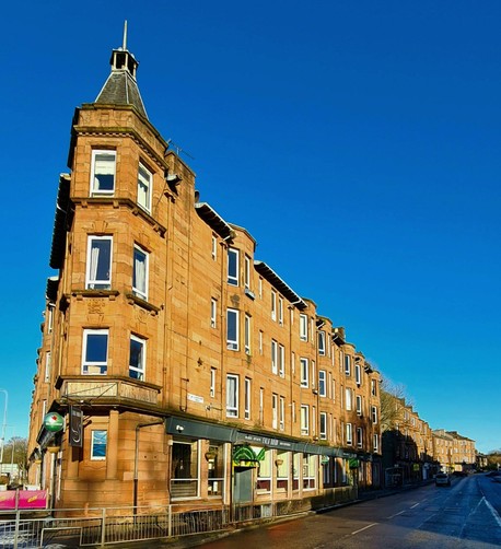 A red sandstone corner tenement in Glasgow.
