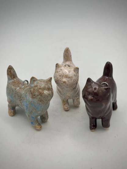 3 handmade pottery cat ornaments in brown/blue, cream and brick