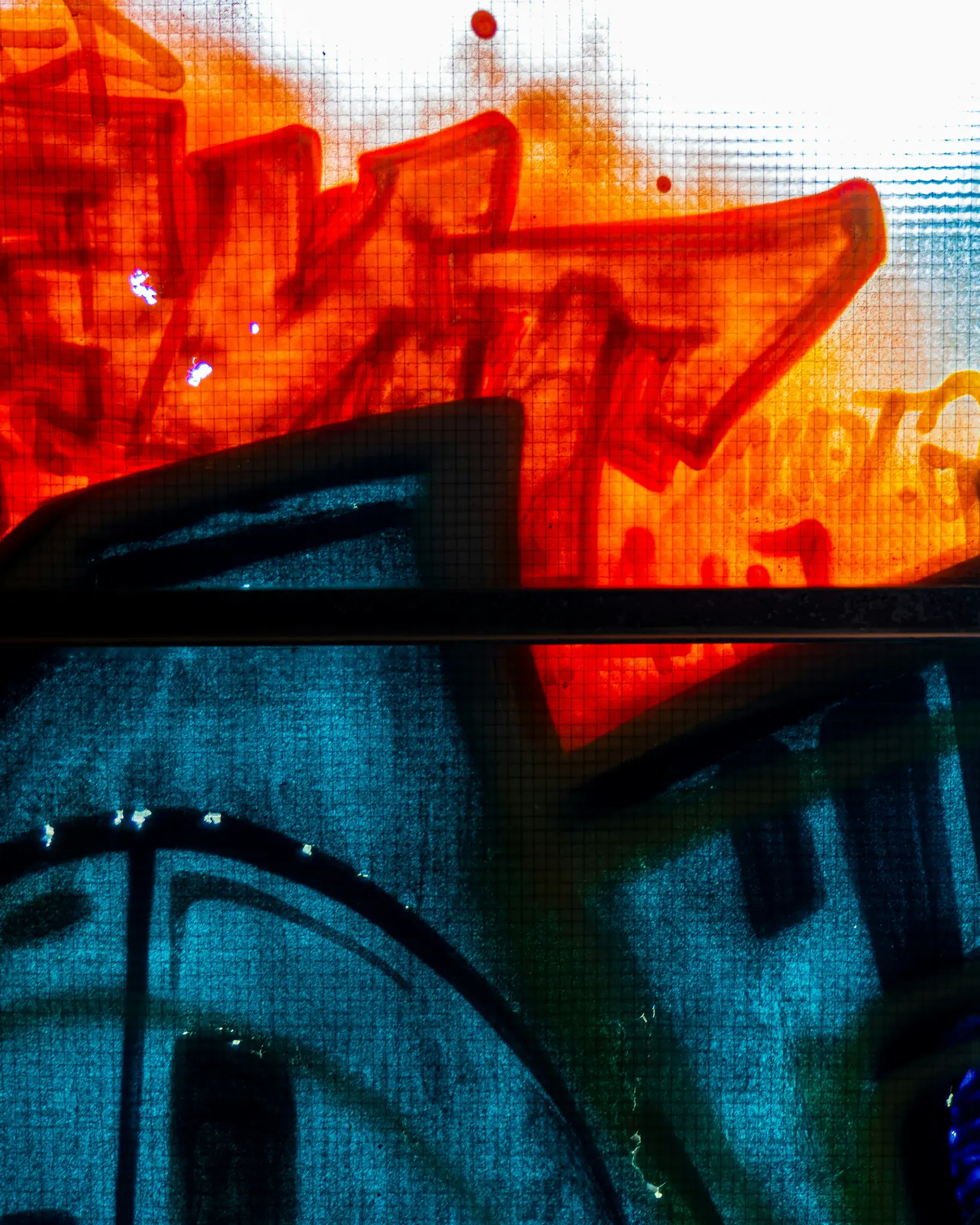 Foto abstracta de primer plano de graffiti. La mitad superior es de color rojo brillante y naranja, mientras que la mitad