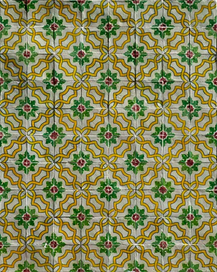 Una vista ravvicinata, a schermo intero, di una parete ricoperta di piastrelle decorative in ceramica con un motivo ripetuto