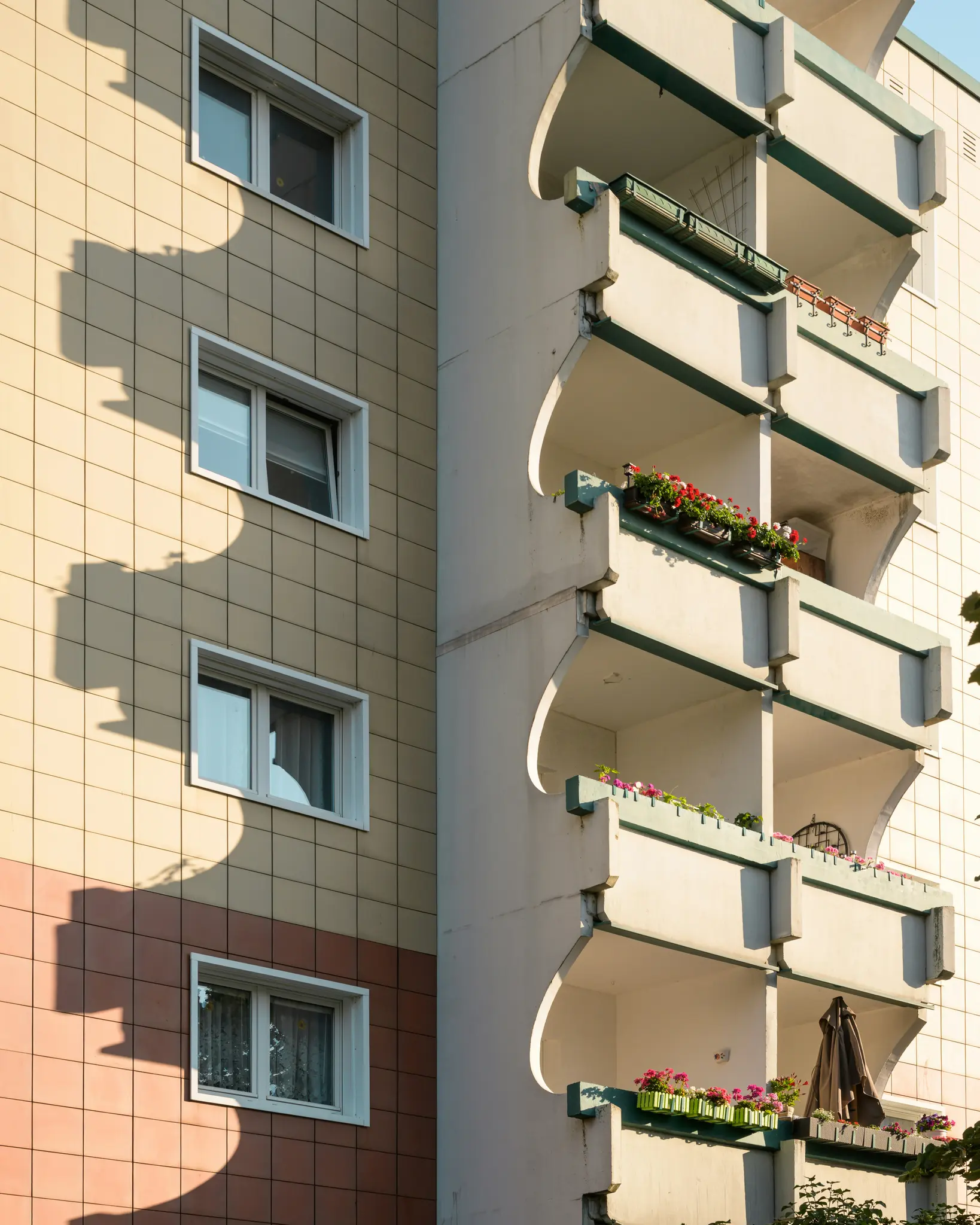 Vista de primer plano y soleada de la fachada de un edificio. El lado izquierdo tiene paredes revestidas de baldosas beige y