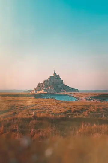 Breite Landschaftsaufnahme von Mont Saint-Michel, einer mittelalterlichen Abtei auf einer felsigen Insel, unter einem Himmel