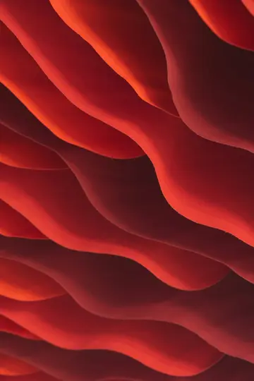 Nahaufnahme eines abstrakten Bildes mit wellenförmigen roten und orangen Wellen, wobei Schatten Tiefe und Textur erzeugen.