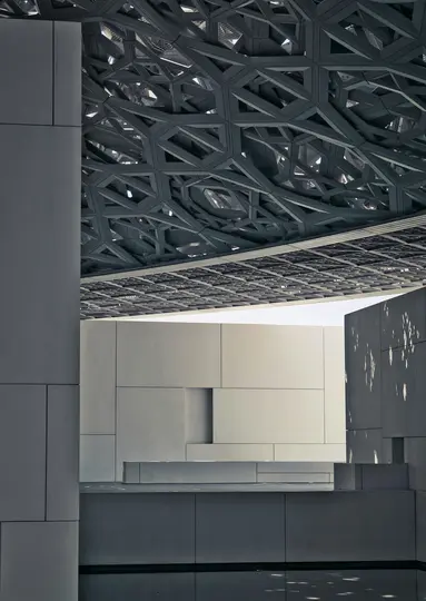 Eine detaillierte Ansicht moderner Architektur mit einem dunklen, kunstvollen geometrischen Dachmuster über hellen