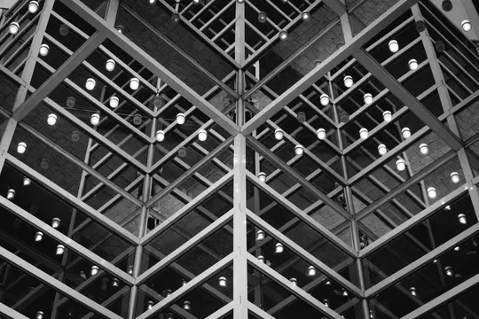 A black and white photo of a complex geometric structure with intersecting beams and glass, featuring many small, glowing…