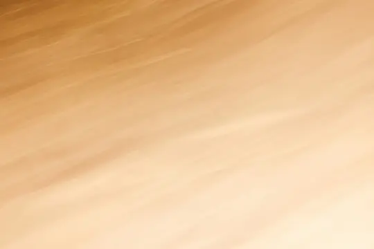 An abstract image featuring diagonal streaks of blurred light in warm tones, transitioning from a darker brown to a lighter…