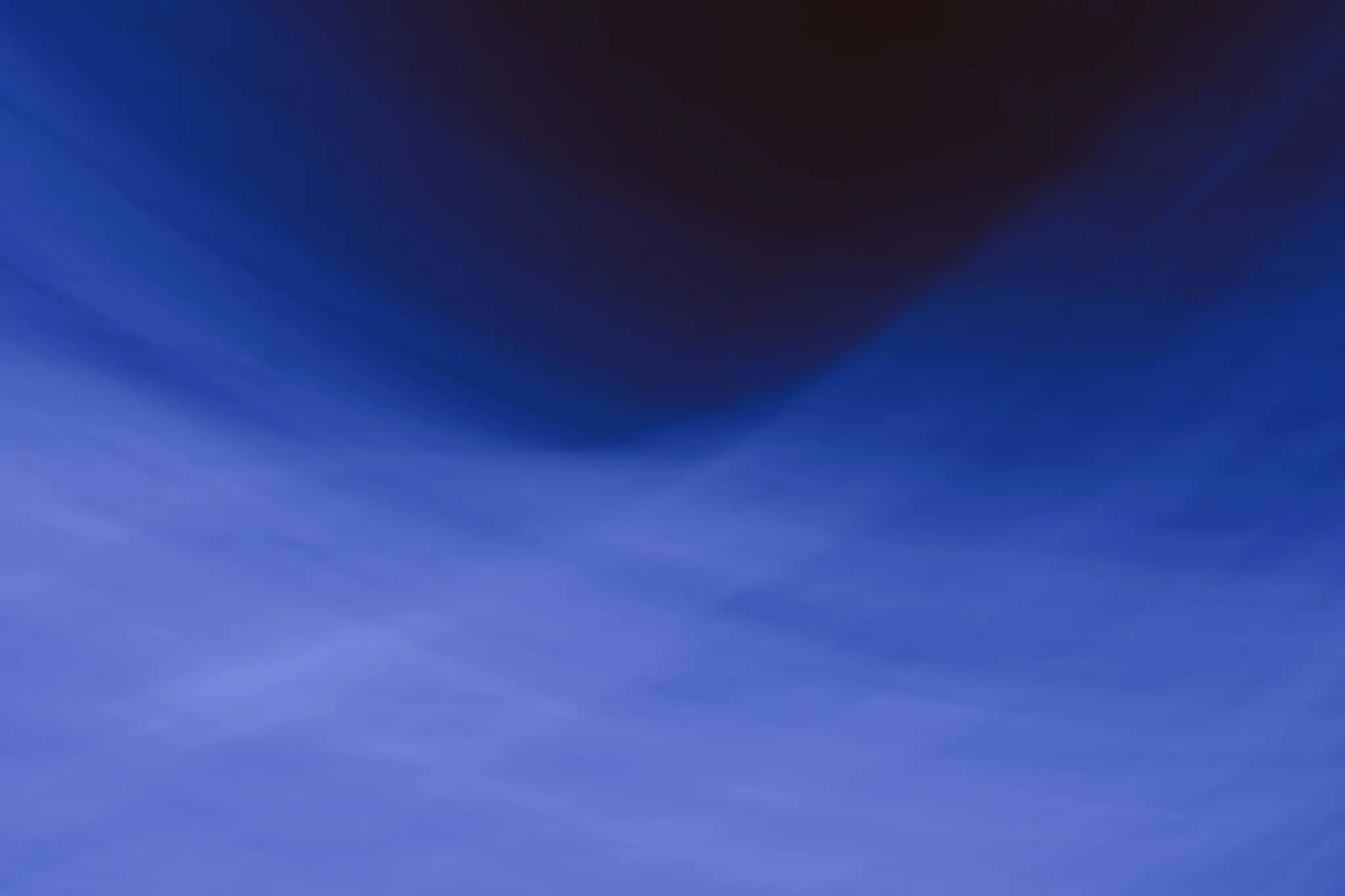 An abstract image with blurred blue tones transitioning from dark indigo at the top to lighter periwinkle at the bottom.…