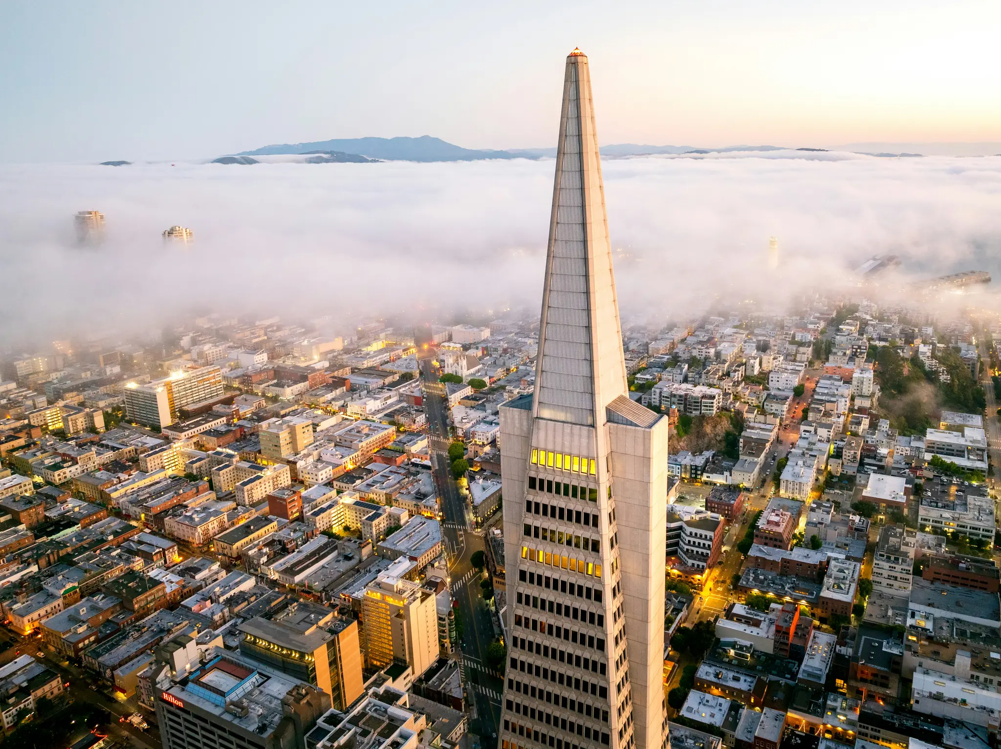 Een luchtfoto van de Transamerica Pyramid-wolkenkrabber die oprijst boven een door mist bedekt stadslandschap van San