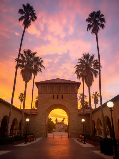 Un arco de piedra con tejado de tejas rojas se alza contra un cielo dramático al atardecer de color naranja, rosa y púrpura.