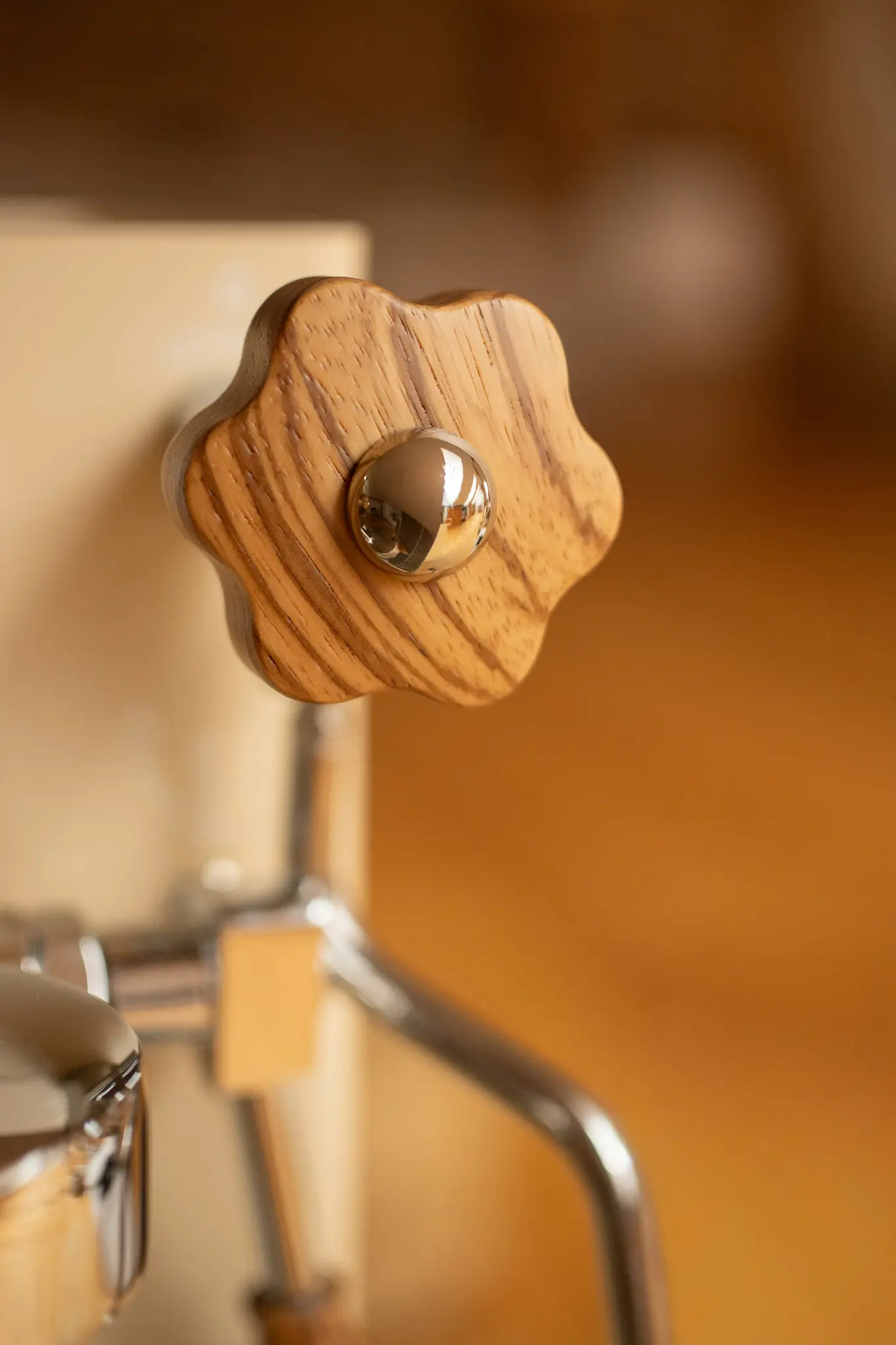 Une photo en gros plan d'un bouton en bois en forme d'étoile avec un centre sphérique chromé, fixé à une machine.