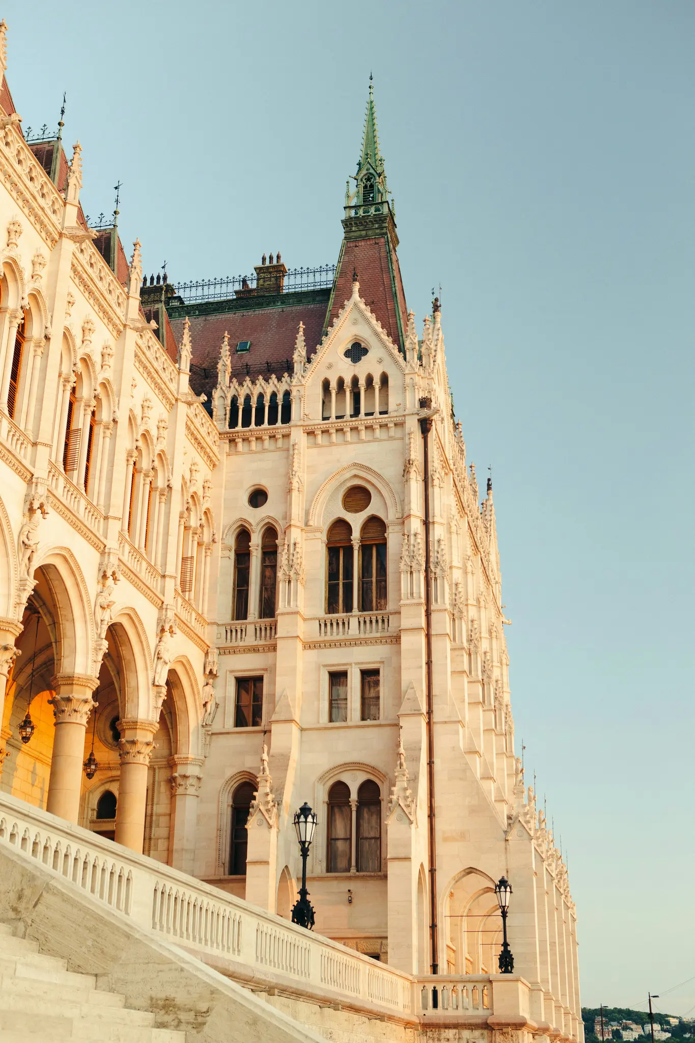 Záběr z nízkého úhlu na velkolepou, světlou budovu se složitou gotickou architekturou, včetně oblouků, oken a...