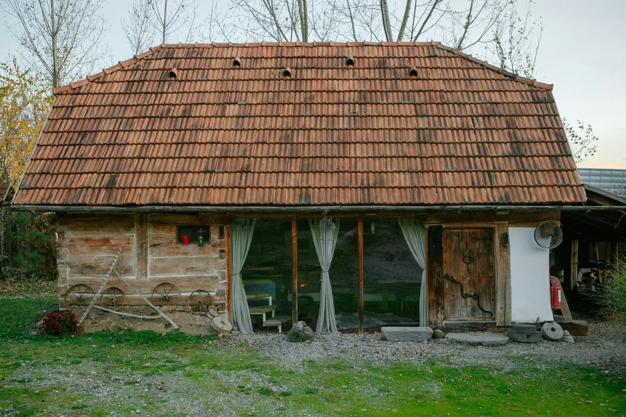 Rujo puurakennus punaisella tiilikattoineen seisoo ruohikkoisella alueella. Rakennuksessa on lasinen etuosa, jossa on…