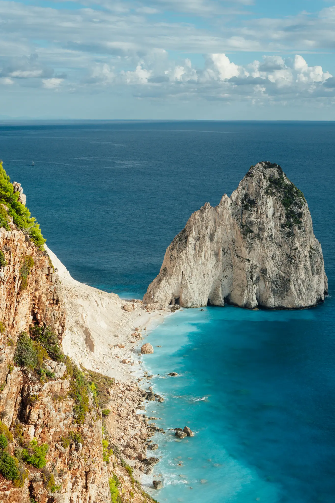 Una vista aerea di una splendida scena costiera con un'imponente formazione rocciosa di colore chiaro che emerge da acque