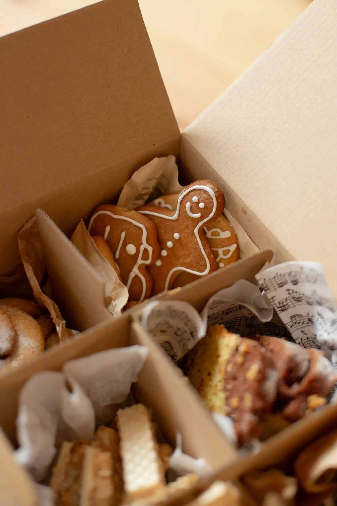 Close-up, van bovenaf genomen foto van een bruine kartonnen doos gevuld met diverse bakkerijproducten, waaronder