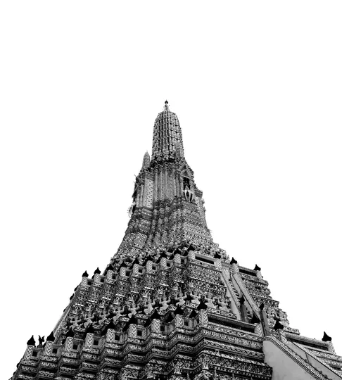 A dramatic low-angle, black and white photo of a tall, intricately decorated temple spire, possibly a prang, against a…