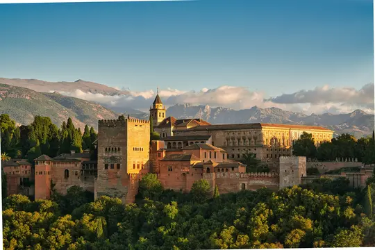 Panoramatický pohľad na komplex paláca a pevnosti Alhambra, zaliaty teplým svetlom zlatej hodinky, obklopený zeleňou...