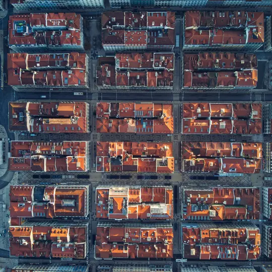 Una vista aérea, de arriba abajo, de una ciudad que muestra muchos edificios con tejados de tejas rojas de terracota