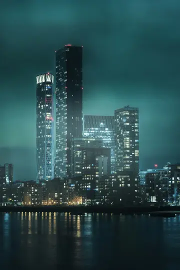 Et natsyn af en bys skyline med flere høje, oplyste skyskrabere og talrige bygninger langs en vandkant…