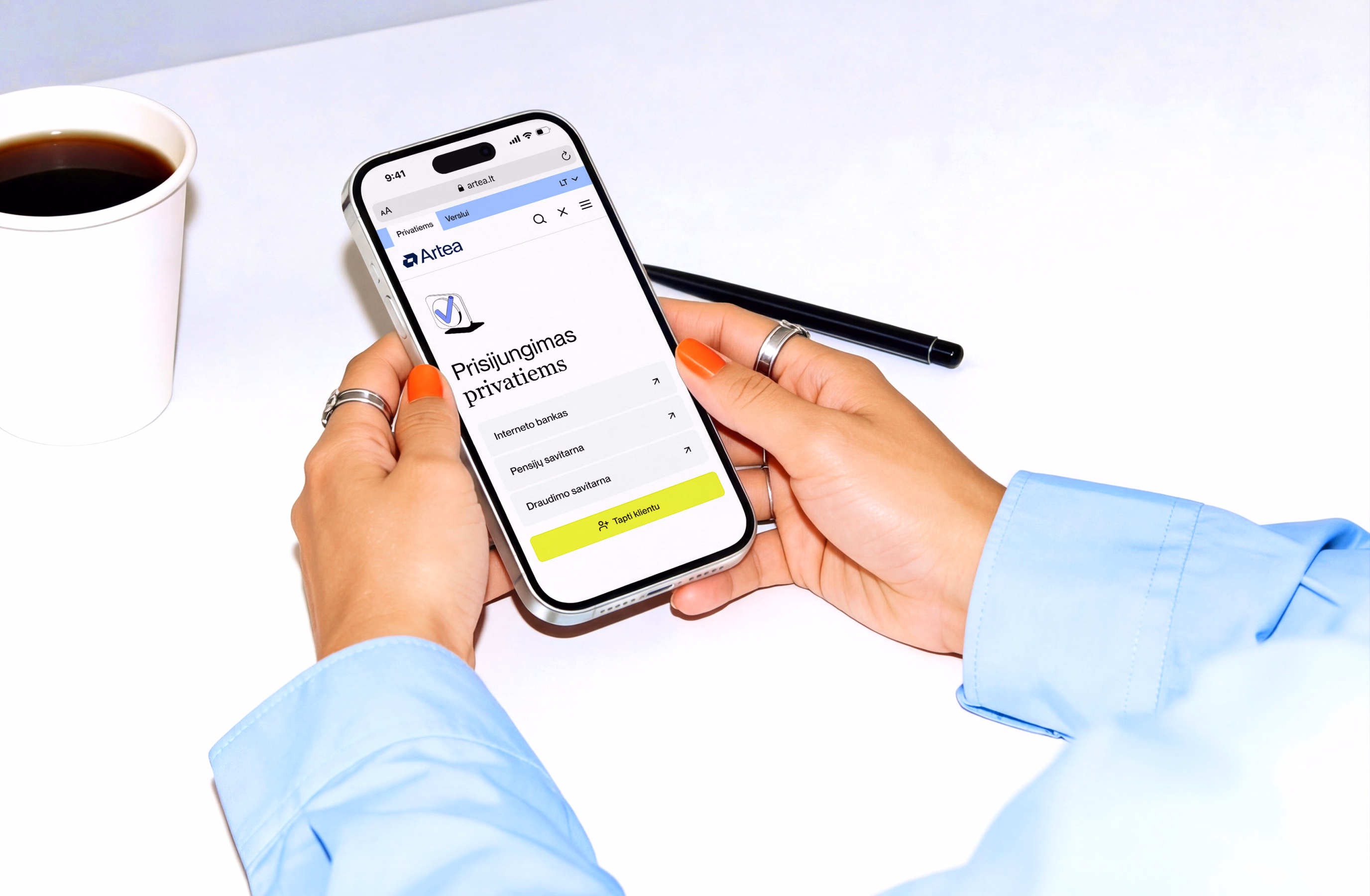 A hand holding a phone showing the Artea mobile app login screen