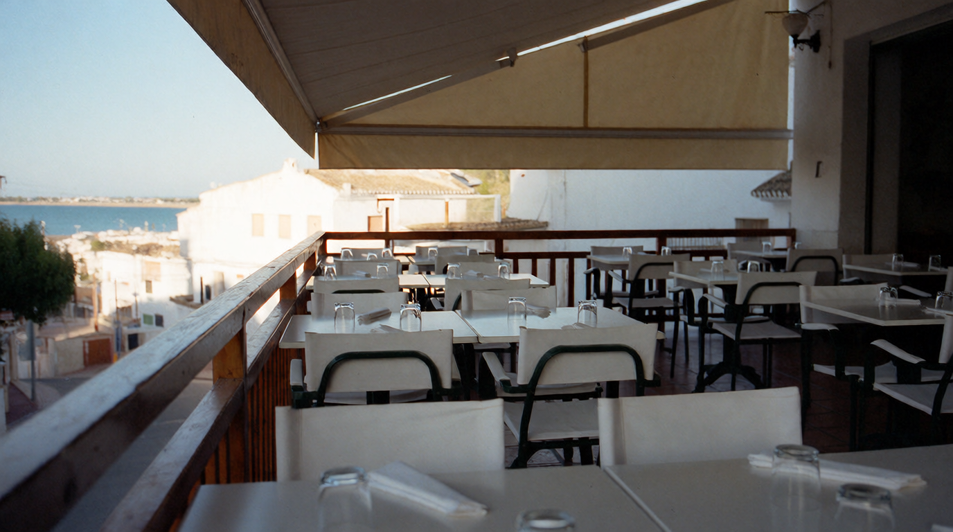 An empty restaurant terrace with tables still set in the mid-afternoon quiet