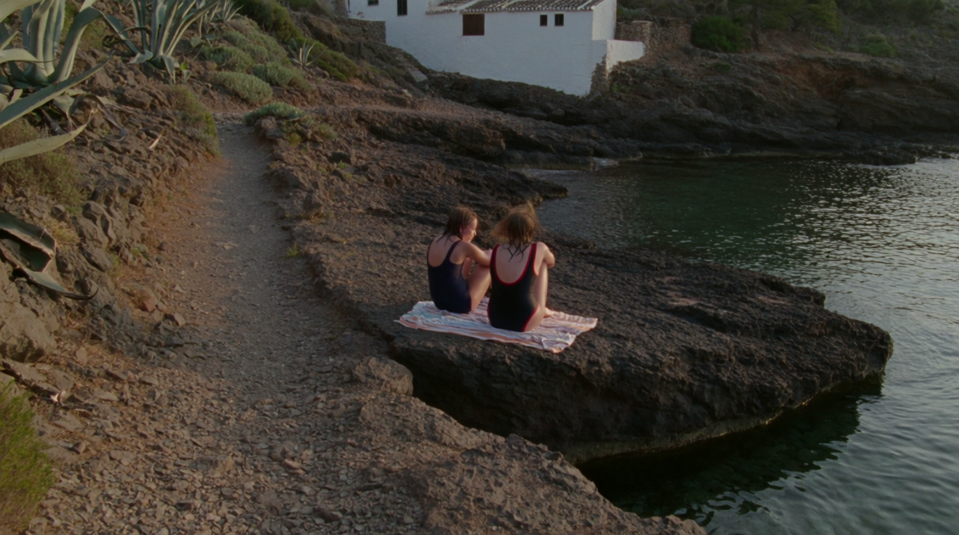 A quiet rocky cove near Benissa with two friends resting on the rocks