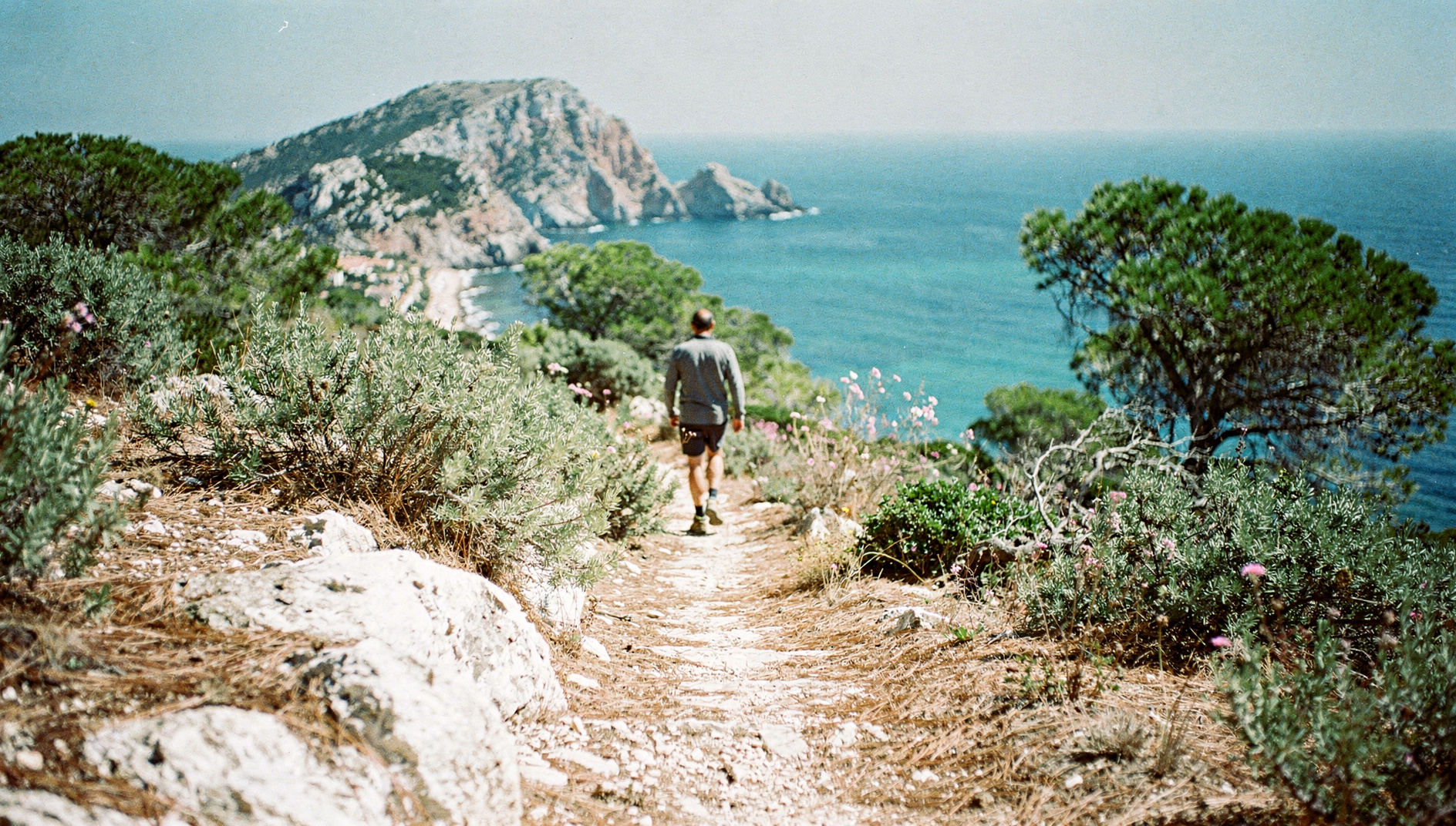 Een wandelaar ver weg op een kalkstenen pad op de Montgó boven de baai van Jávea
