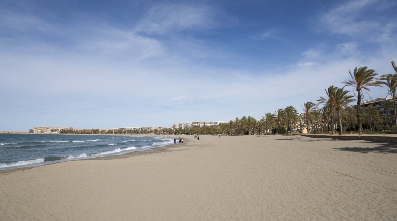 En höststrand på Orihuela Costa med några som går på promenad