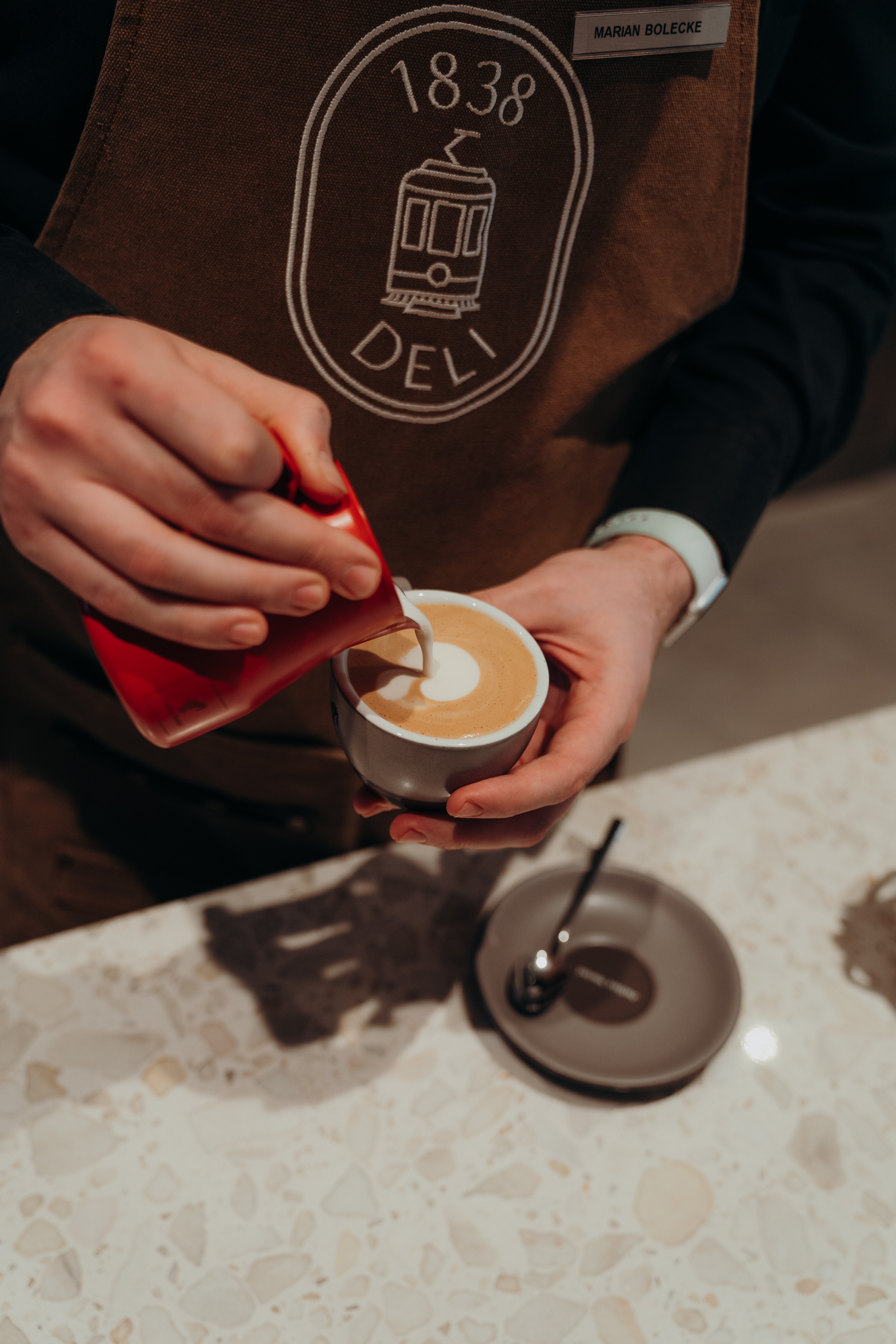 Barista macht einen Cappuccino mit Latte Art