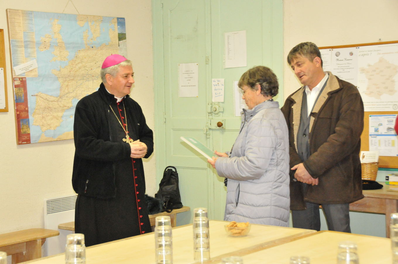 Monseigneur Aillet remet à Geneviève un livre d'or pour les pèlerins