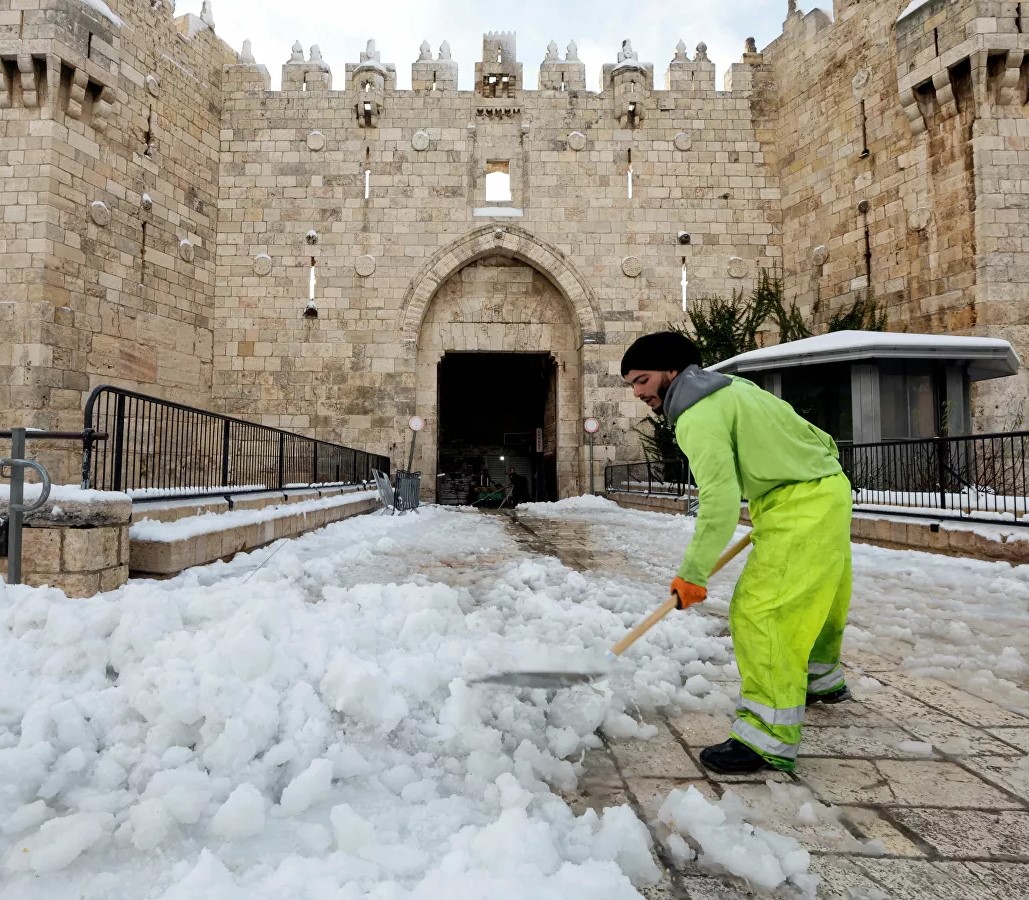zUn homme déblaie la neige devant la porte de Damas à Jérusalem.jpg