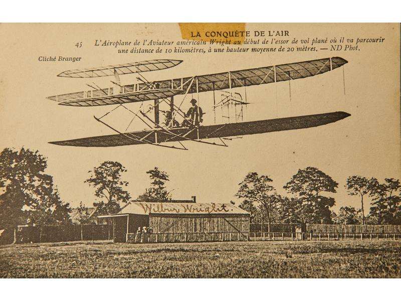 Carte postale ancienne représentant Wilbur Wright dans son premier vol plané