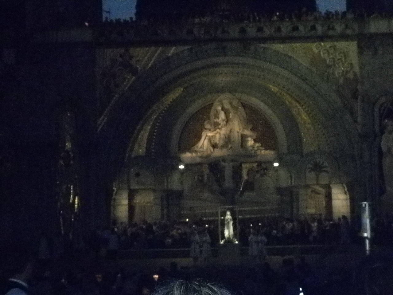 La statue illuminée est déposée devant la basilique du Rosaire. On prie.