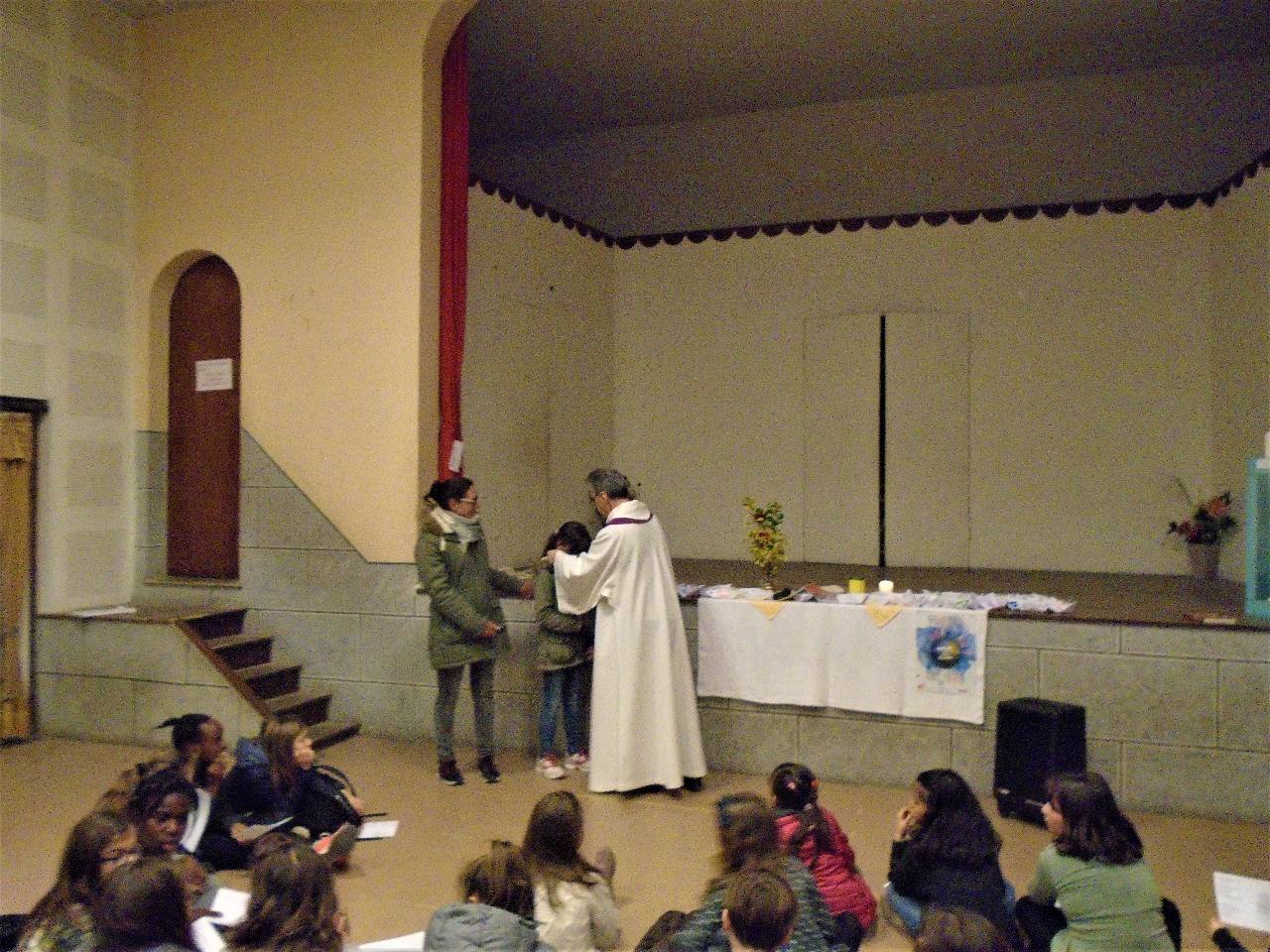 L'abbé Jean-Marc donne à Sarah une petite Croix