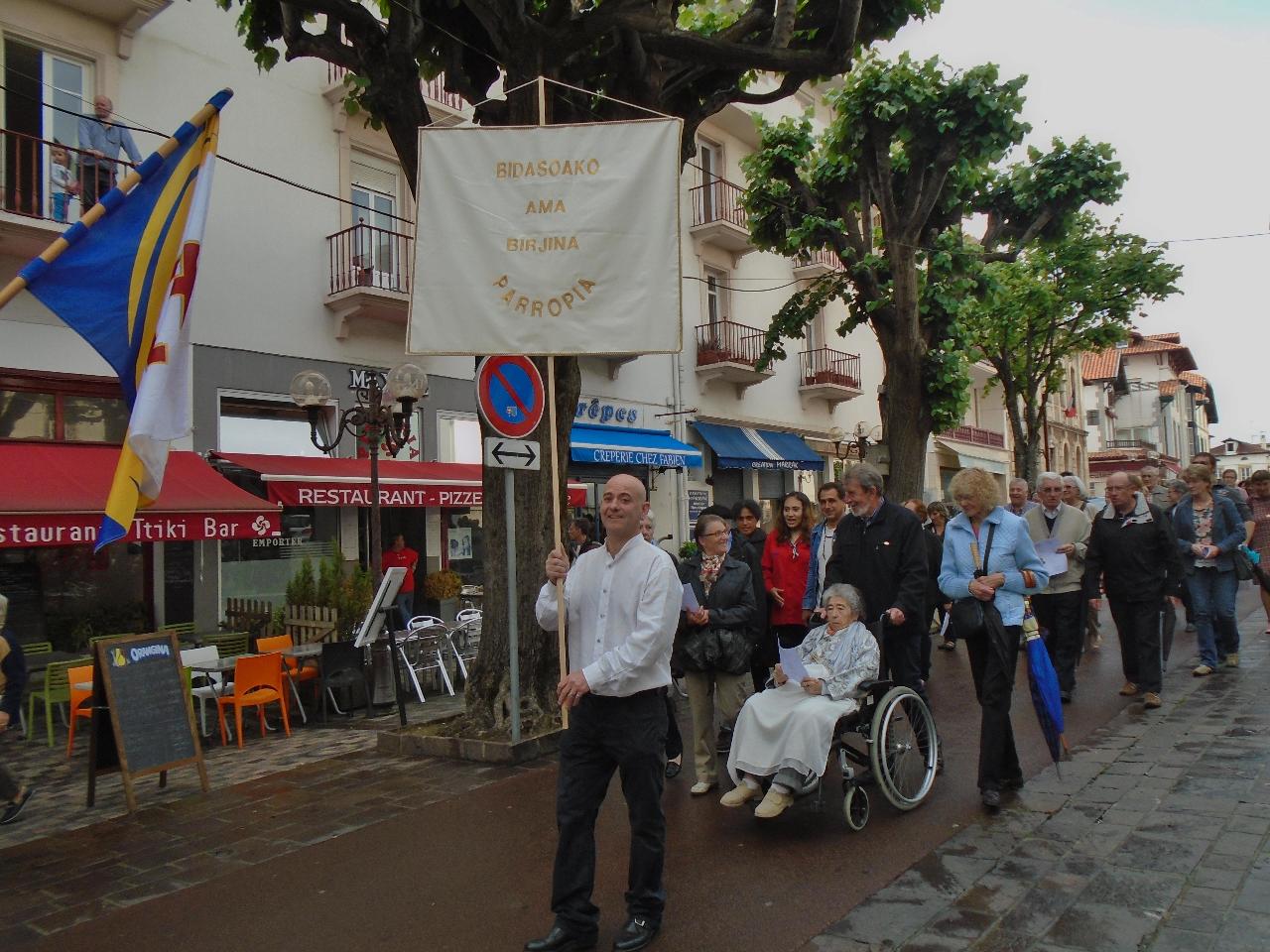 Derrière le drapeau des scouts, Christophe, père de famille, porte la bannière en basque