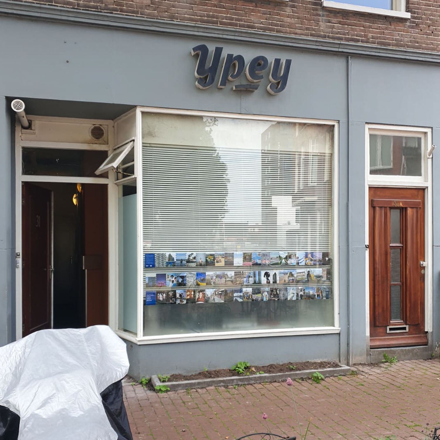 Exhibition of postcards displayed in a large window on a street in Groningen, The Netherlands, with 'a sign reading 'Ypey' above.
