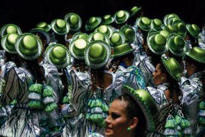 Photograph of Caporales at Carnaval de Oruro, wearing shiny green hats.